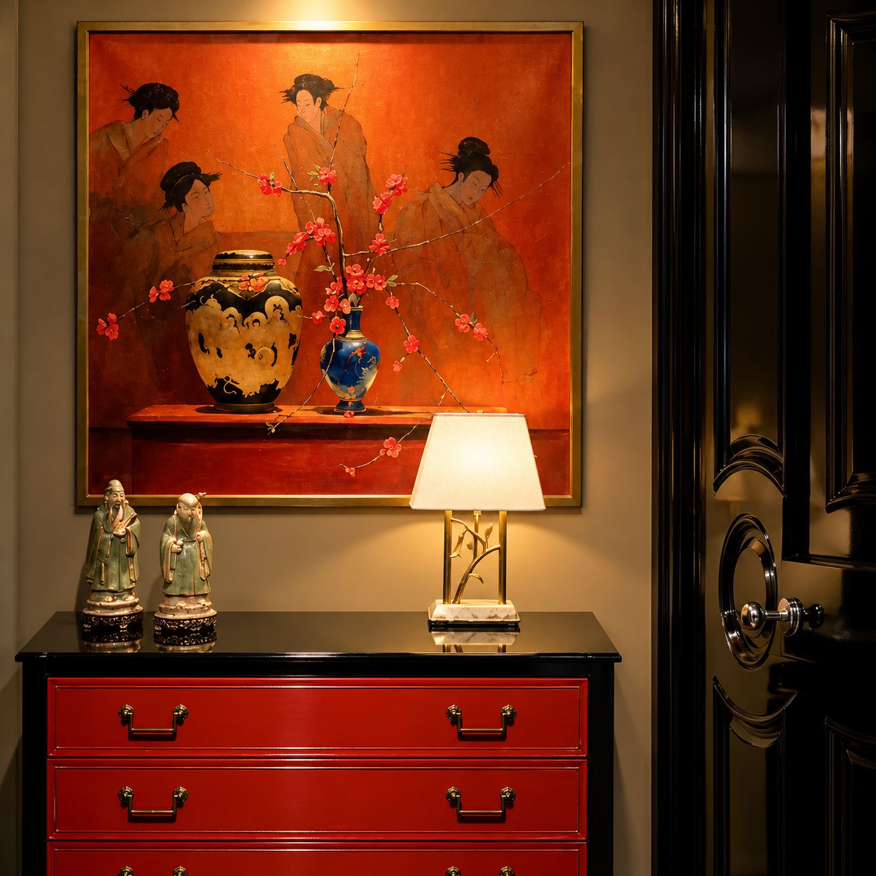 Red chest of drawers with a lamp, a ginger jar and small figurines beneath a large painting of figures on an orange ground